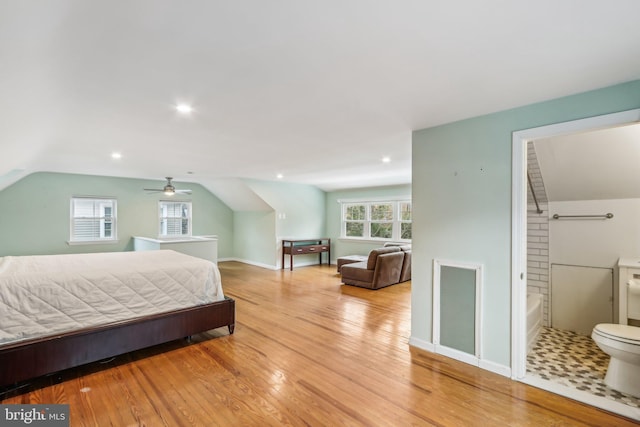 bedroom featuring multiple windows, vaulted ceiling, and light hardwood / wood-style flooring