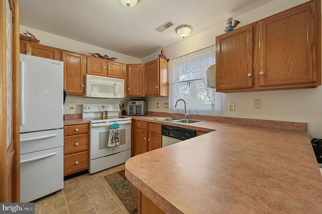 kitchen featuring white appliances, kitchen peninsula, and sink