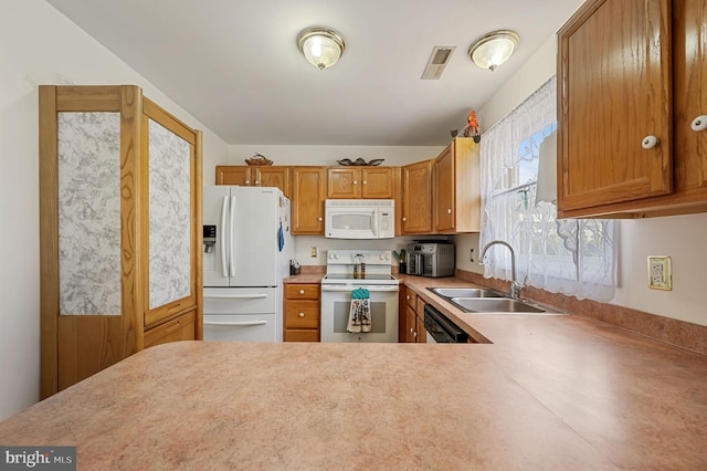 kitchen featuring white appliances, kitchen peninsula, and sink