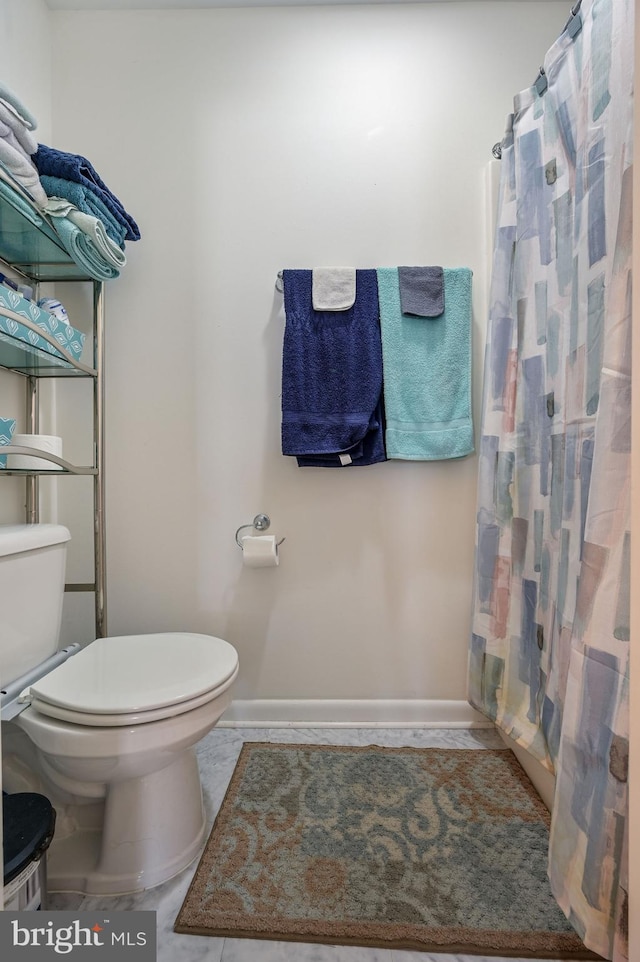 bathroom with a shower with curtain and toilet