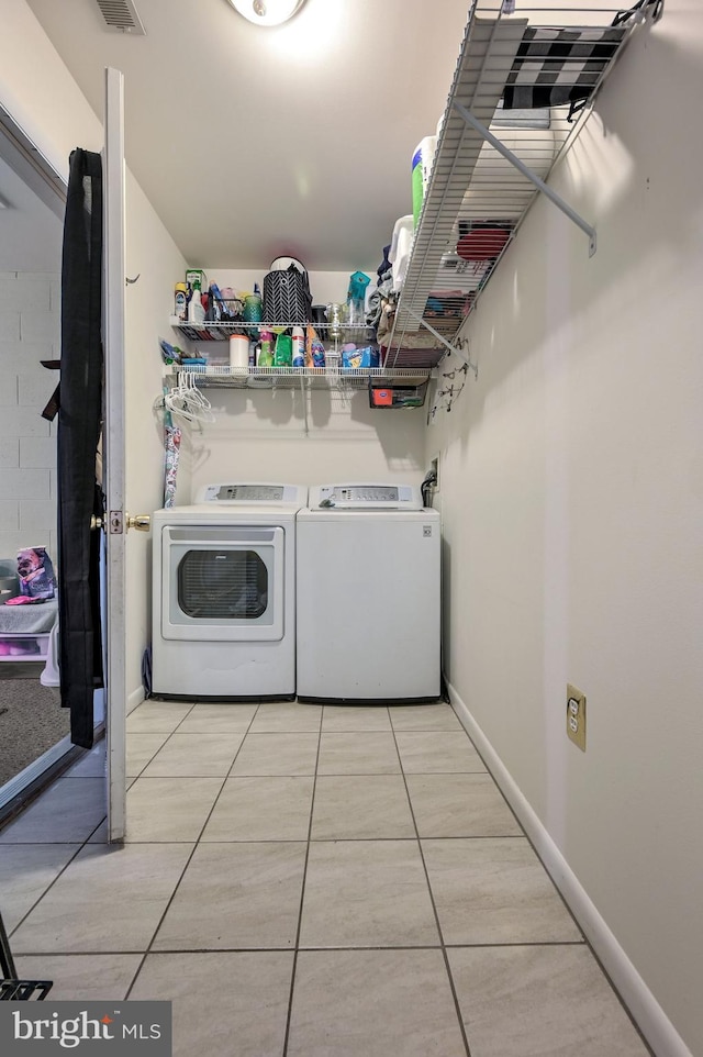 washroom with light tile patterned flooring and washer and clothes dryer