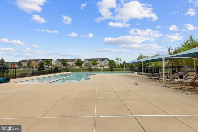 pool with a residential view, fence, and a patio