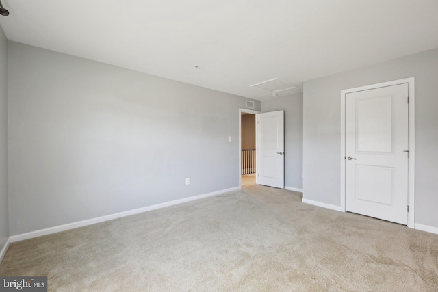 unfurnished bedroom featuring attic access, visible vents, baseboards, and light colored carpet