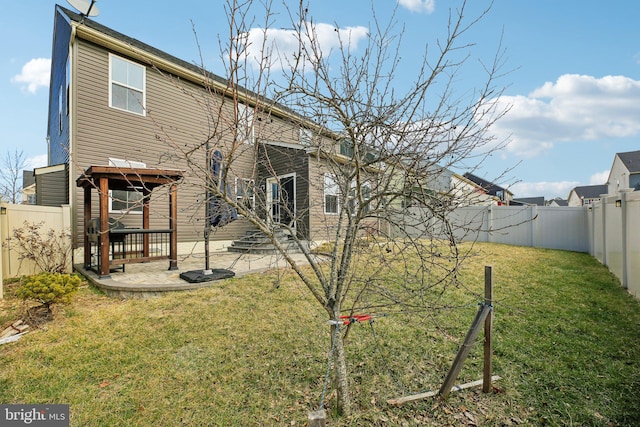 back of property featuring a yard, a patio area, and a fenced backyard