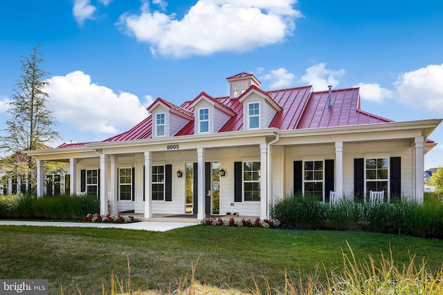 view of front of home featuring metal roof, a porch, a standing seam roof, and a front yard