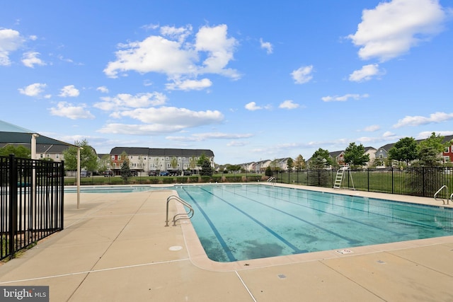 pool with fence and a residential view