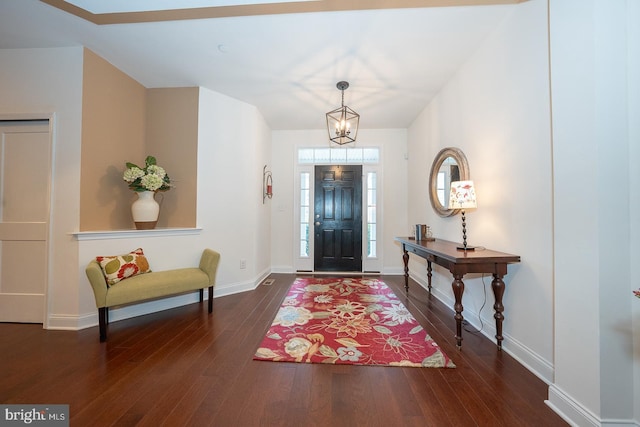 entryway featuring dark hardwood / wood-style flooring and an inviting chandelier