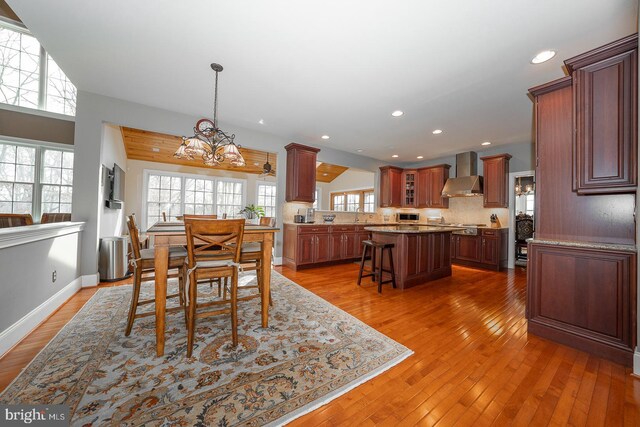 dining area with recessed lighting, a notable chandelier, baseboards, and wood finished floors