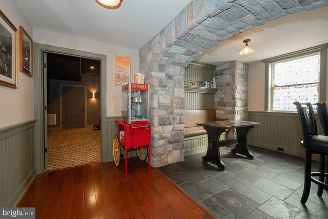 interior space with a wainscoted wall and dark wood-style flooring