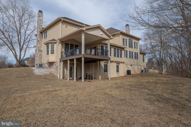 back of house with central AC, a yard, and a chimney