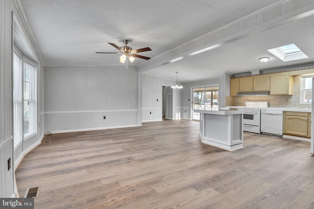 kitchen featuring pendant lighting, white appliances, a skylight, and light wood-type flooring