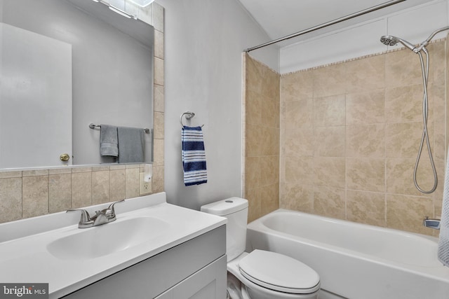 full bathroom featuring vanity, tiled shower / bath combo, and toilet