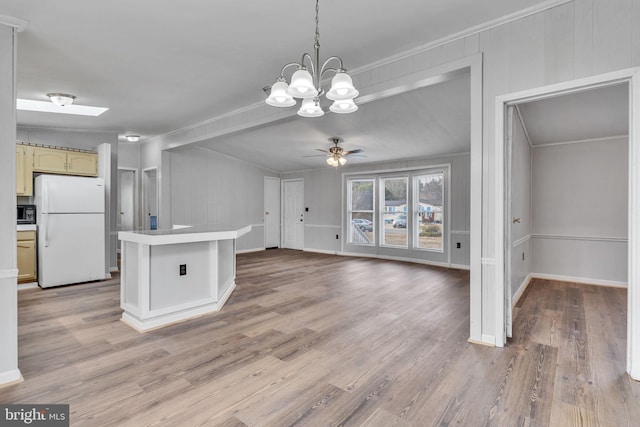 kitchen featuring white refrigerator, crown molding, and light hardwood / wood-style flooring