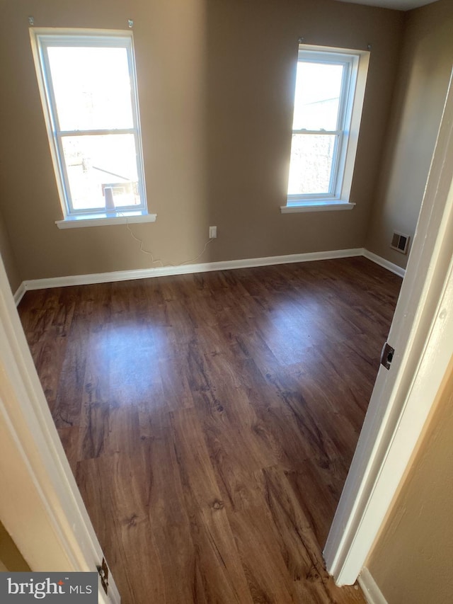 empty room with dark hardwood / wood-style floors