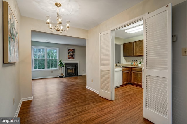 interior space featuring wood finished floors, a fireplace, a sink, and baseboards