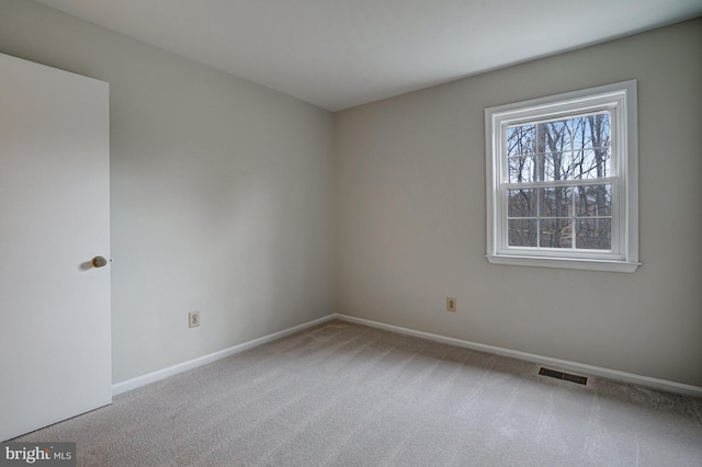 unfurnished room with baseboards, visible vents, and carpet flooring