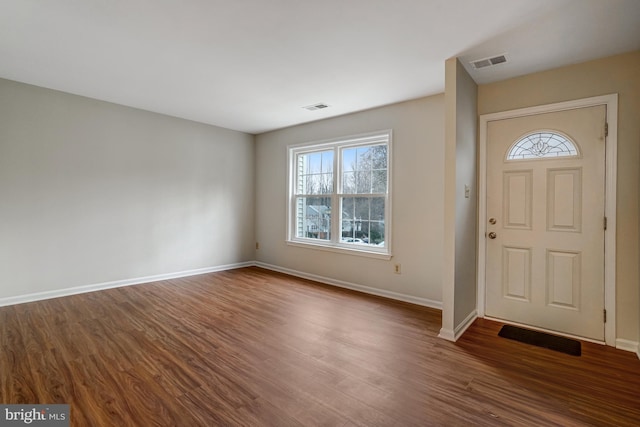 foyer with baseboards, visible vents, and wood finished floors