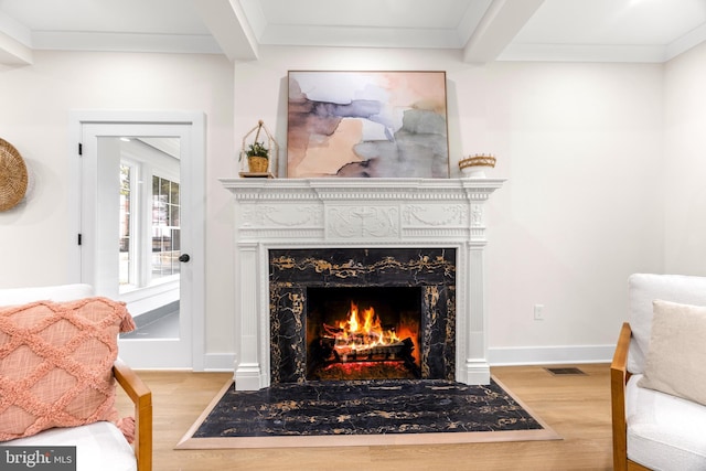 living area featuring ornamental molding, a fireplace, and light hardwood / wood-style flooring