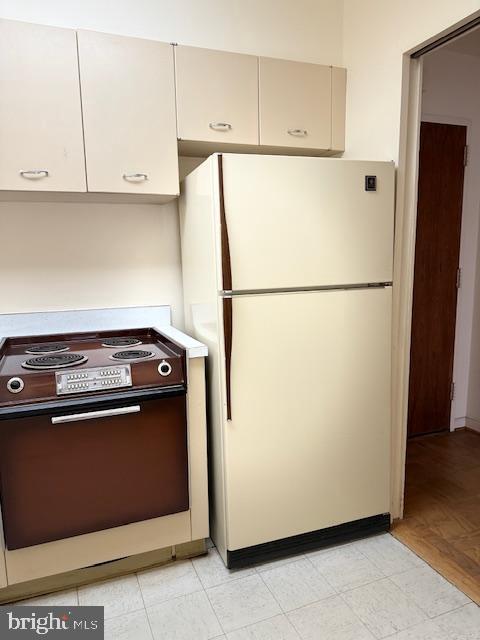 kitchen with electric range and white fridge