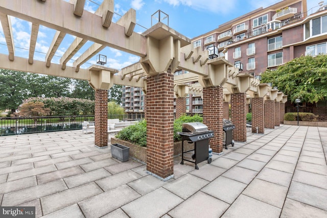 view of patio / terrace with a water view and a grill