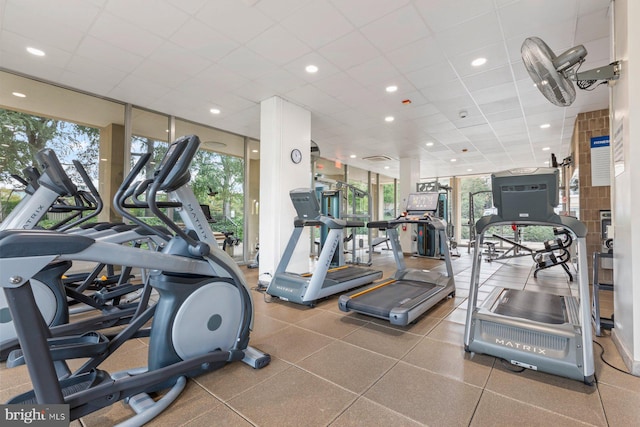 exercise room with a drop ceiling, a wealth of natural light, and a wall of windows