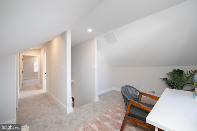 carpeted home office featuring vaulted ceiling