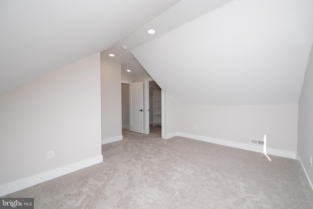 additional living space with vaulted ceiling and light colored carpet