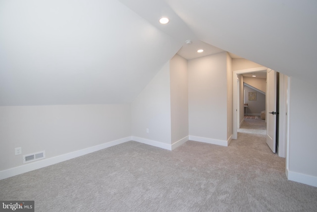 additional living space with vaulted ceiling and light carpet