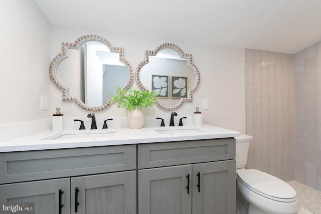 bathroom featuring vanity, tiled shower, and toilet