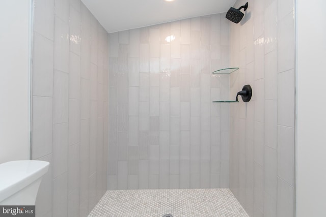 bathroom with toilet and a tile shower