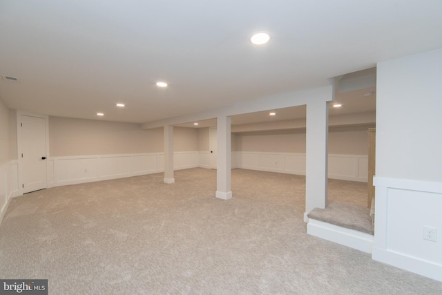 basement featuring light colored carpet