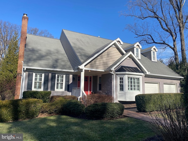 cape cod home featuring a garage and a front lawn