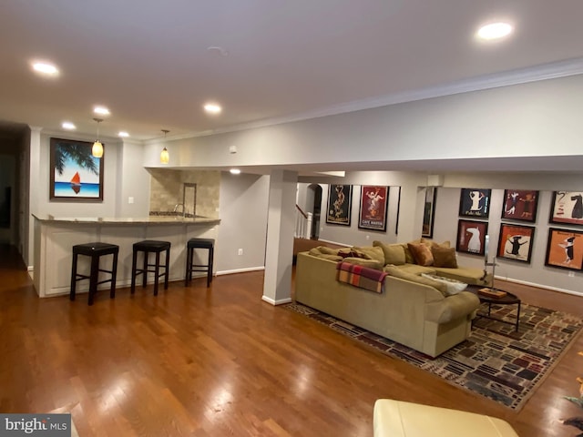 living room with dark wood-type flooring, bar area, and crown molding