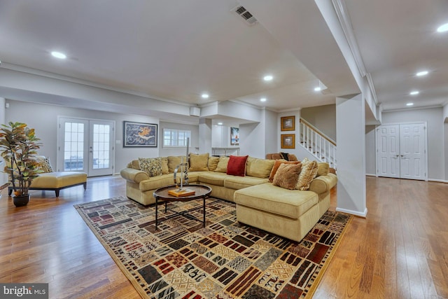 living room featuring hardwood / wood-style flooring, ornamental molding, and french doors