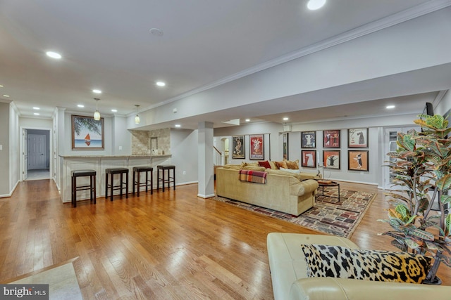 living room with ornamental molding and light hardwood / wood-style floors