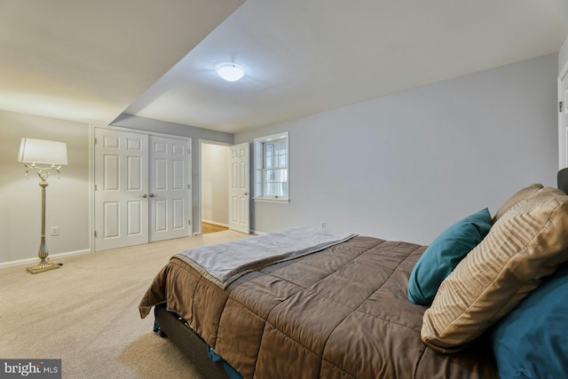 bedroom featuring light colored carpet and a closet