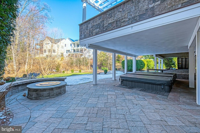 view of patio with an outdoor fire pit and a covered hot tub