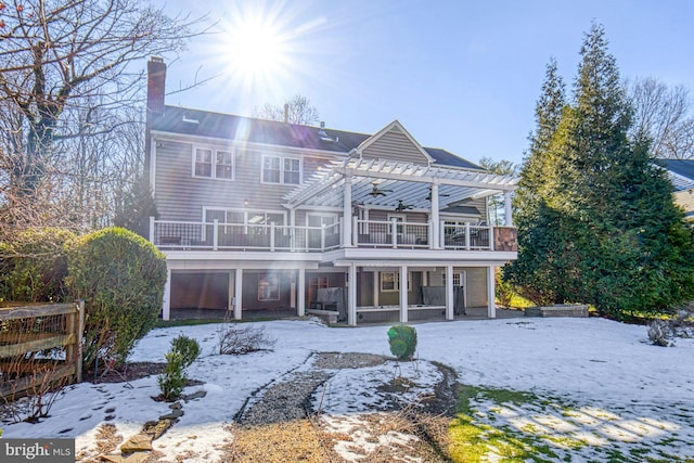 snow covered property with a balcony and a pergola