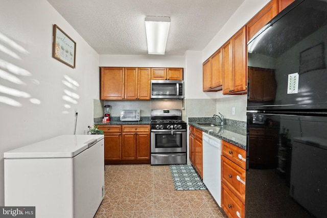 kitchen featuring sink, stainless steel appliances, and a textured ceiling