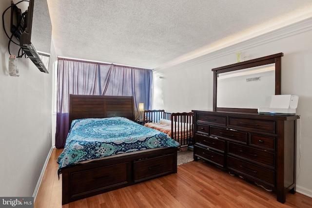 bedroom featuring a textured ceiling and light wood-type flooring