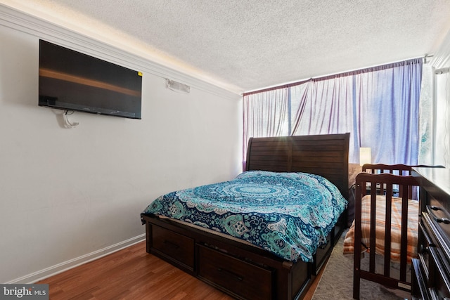 bedroom featuring hardwood / wood-style floors and a textured ceiling