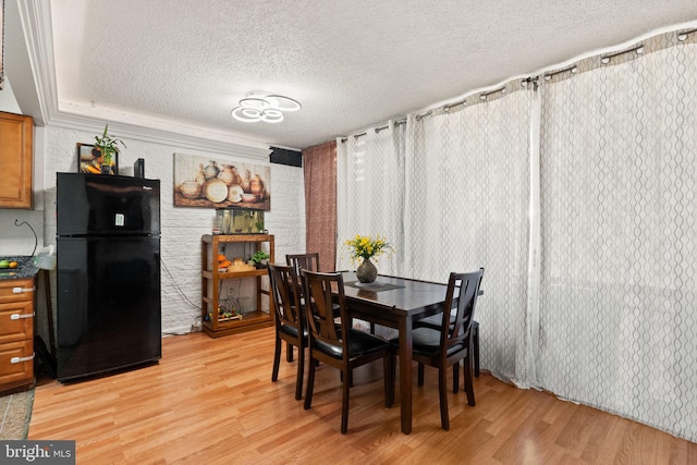 dining space with light hardwood / wood-style flooring and a textured ceiling