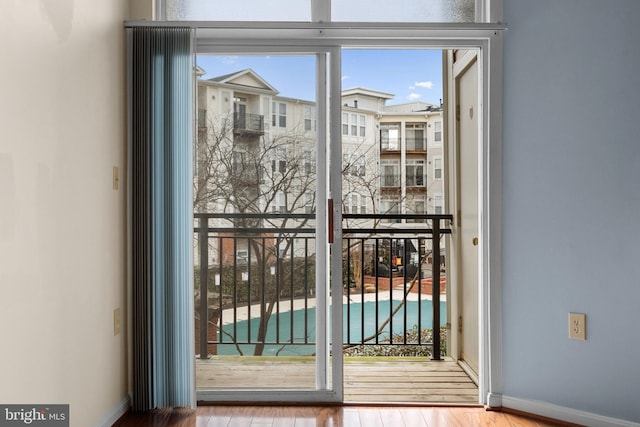 doorway to outside featuring wood finished floors and baseboards