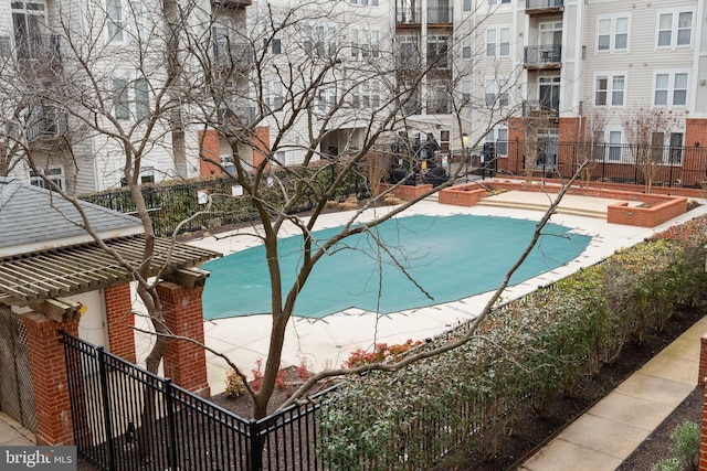 view of swimming pool featuring community basketball court and fence