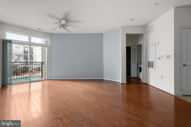 unfurnished room with visible vents, a ceiling fan, wood finished floors, washer / dryer, and baseboards