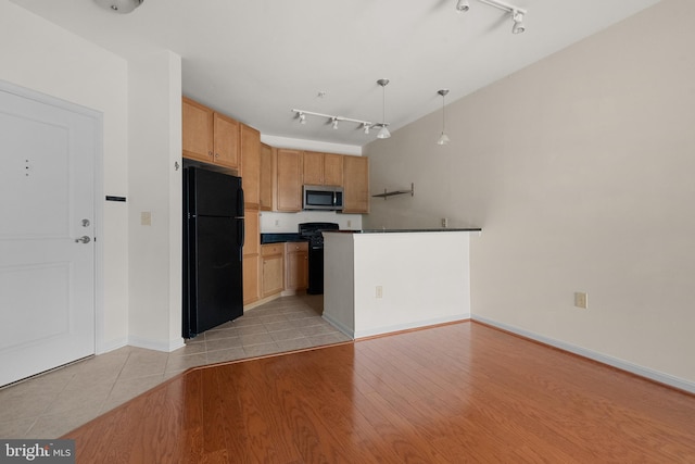 kitchen featuring decorative light fixtures, dark countertops, rail lighting, light wood-type flooring, and black appliances