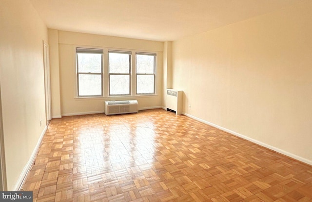 unfurnished room featuring radiator heating unit and light parquet flooring