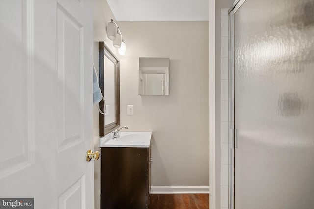 bathroom featuring vanity, an enclosed shower, and wood-type flooring