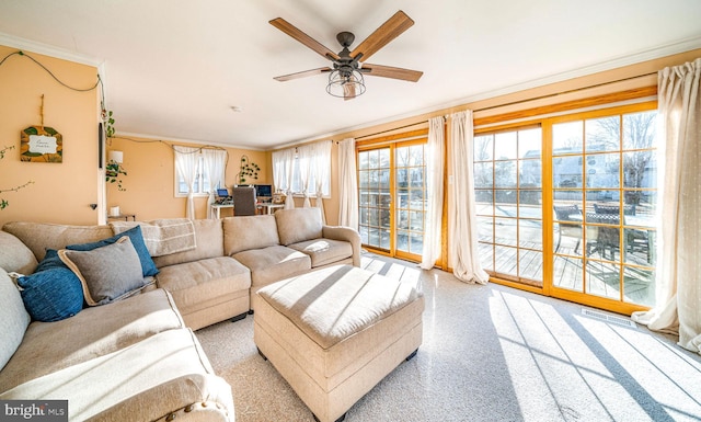 living room with ornamental molding and ceiling fan