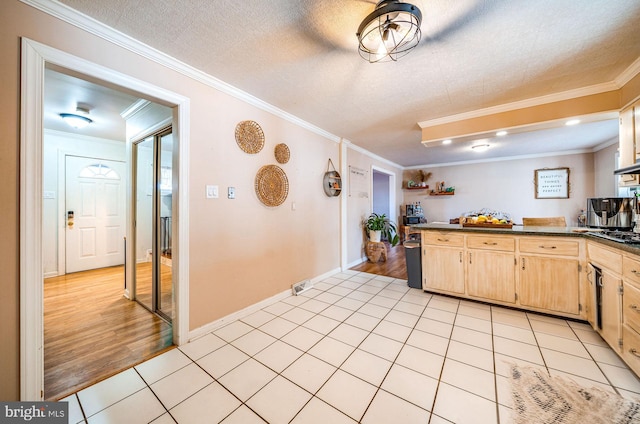 kitchen with light brown cabinetry, light tile patterned floors, ornamental molding, and a textured ceiling